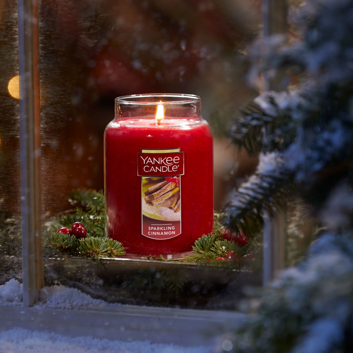 Yankee Candle Sparkling Cinnamon Large Jar lit in a winter window