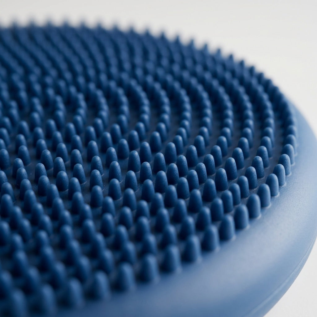 Macro detail of the blue fdmt Wiggle Seat sensory cushion showing rows of tactile soft nubs.