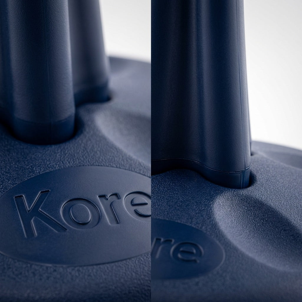 Macro detail of the fdmt Kore Wobble Stool base showing the textured dark blue plastic and logo.